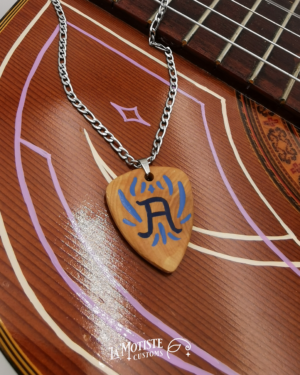 Photo du collier médiator initiale A. Le médiator est en bois de buis, le A en lettrage fin bleu marine et les ornements qui l'entourent en bleu. Face A