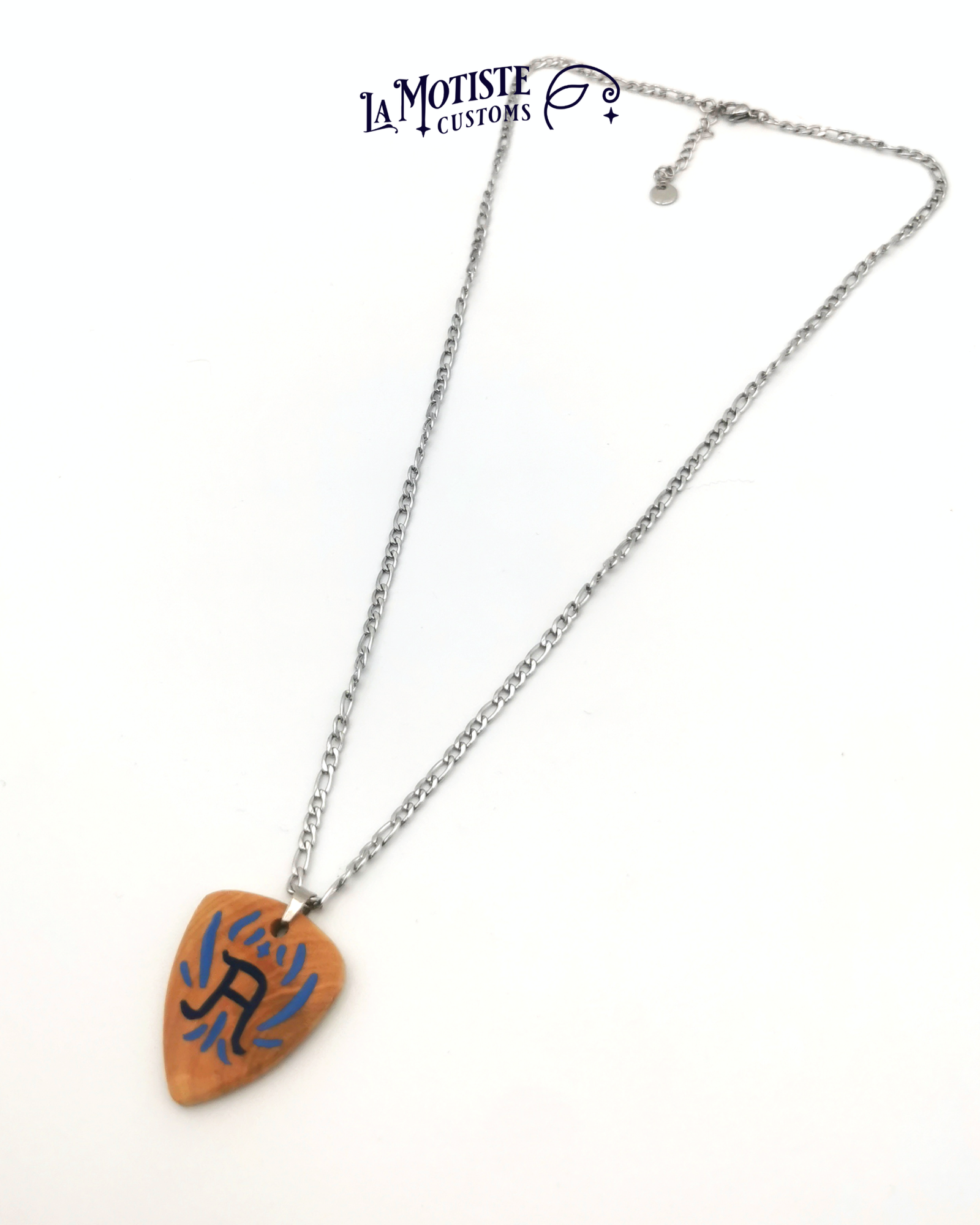 Photo du collier médiator initiale A. Le médiator est en bois de buis, le A en lettrage fin bleu marine et les ornements qui l'entourent en bleu.