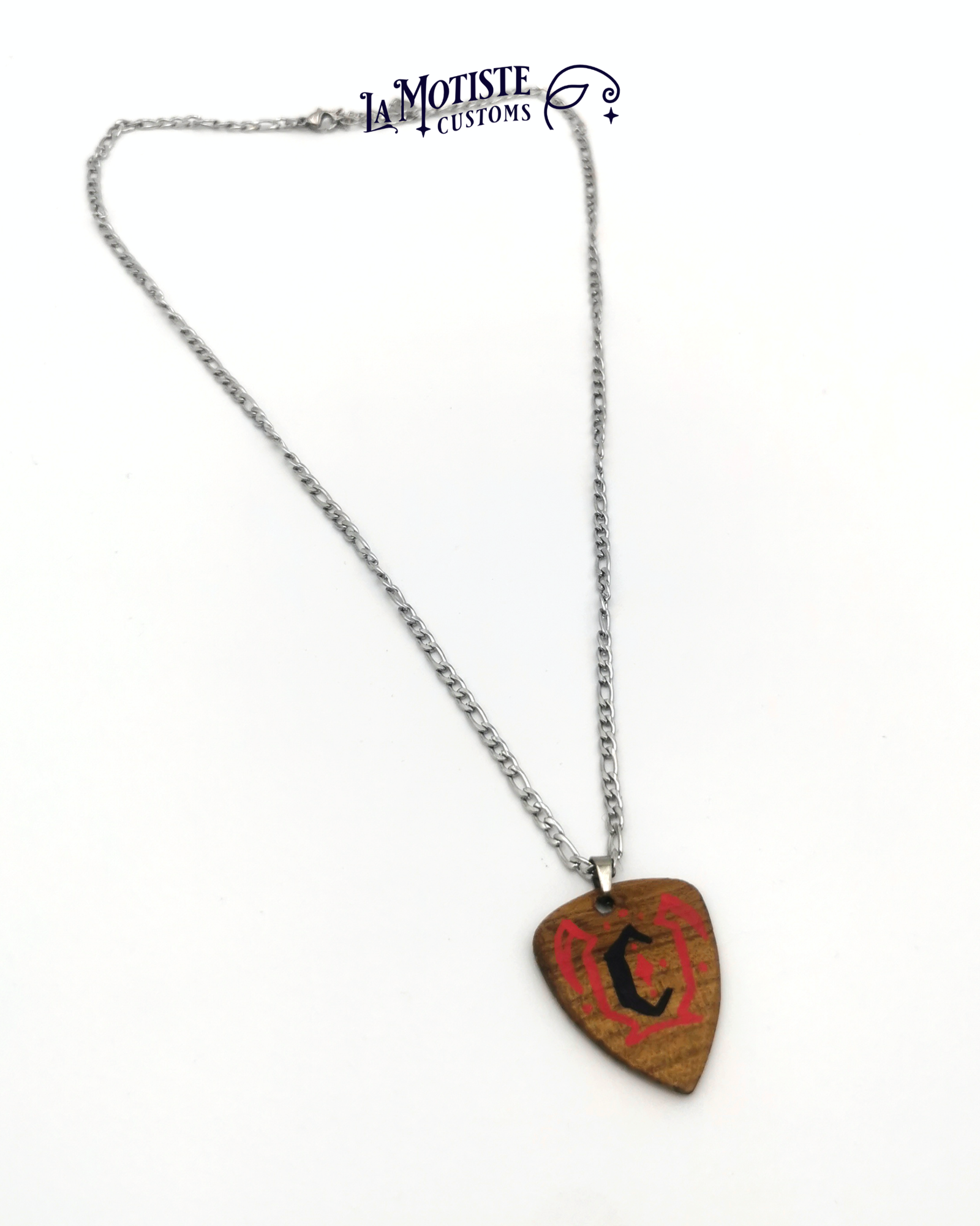 Photo du collier médiator initiale C. Le médiator est en bois d'Orme, le C en lettrage gothique noir et les motifs pinstriping qui l'entourent en rouge. Vue entière du collier face a.