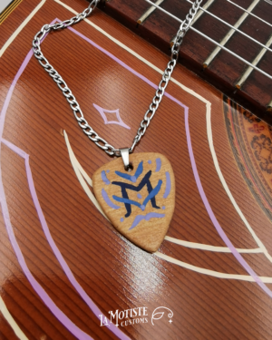 Photo du collier médiator initiale M. Le médiator est en bois de tilleul, le M en lettrage fin bleu marine et les ornements qui l'entourent en bleu. Face A