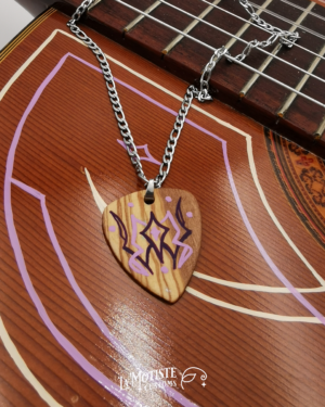 Photo du collier médiator Pinstriping lavande. Motif d'inspiration pinstriping autour d'un diamant en violet et lavande, sur bois d'olivier. Peint à la main sur les deux faces. Face A