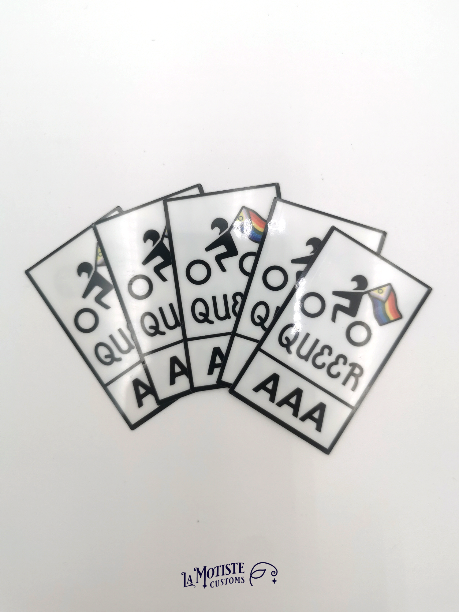 Stickers pelliculé en plastique recyclé Queer AAA. l'icône de motard porte un drapeau lgbtqia+ inclusif, texte Queer AAA